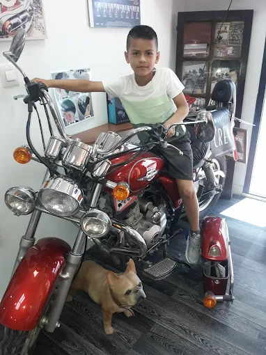 Ni&ntilde;o sentado en una moto roja dentro de Macabich